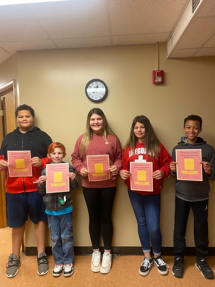 November students of the month stand in a line and hold up their certificates  