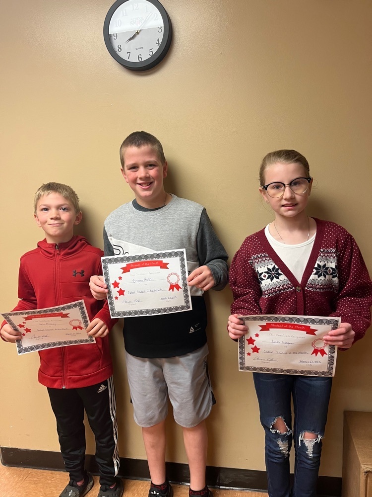 Jase, Brogan, and Lola hold up their student of the month certificates